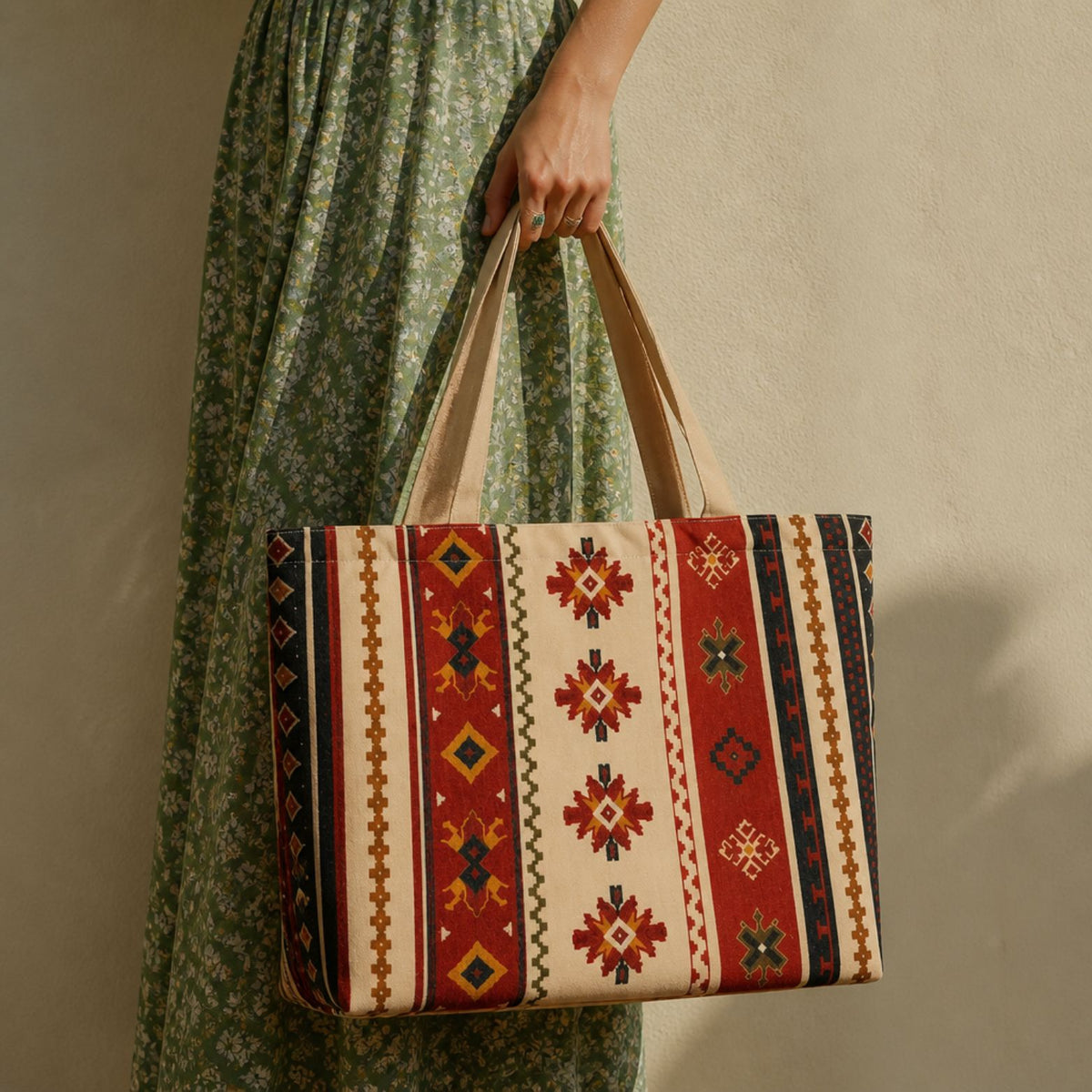 Sonora desert-stripe tote bag held beside a green summer dress
