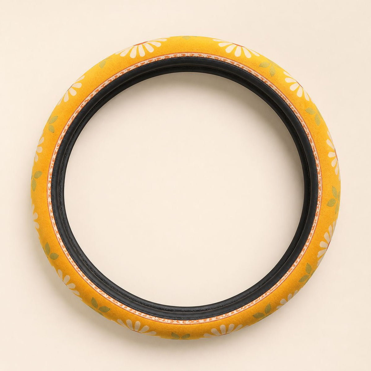 Daisy steering wheel cover by Solara laid flat: mustard and cream daisy print with a black inner band