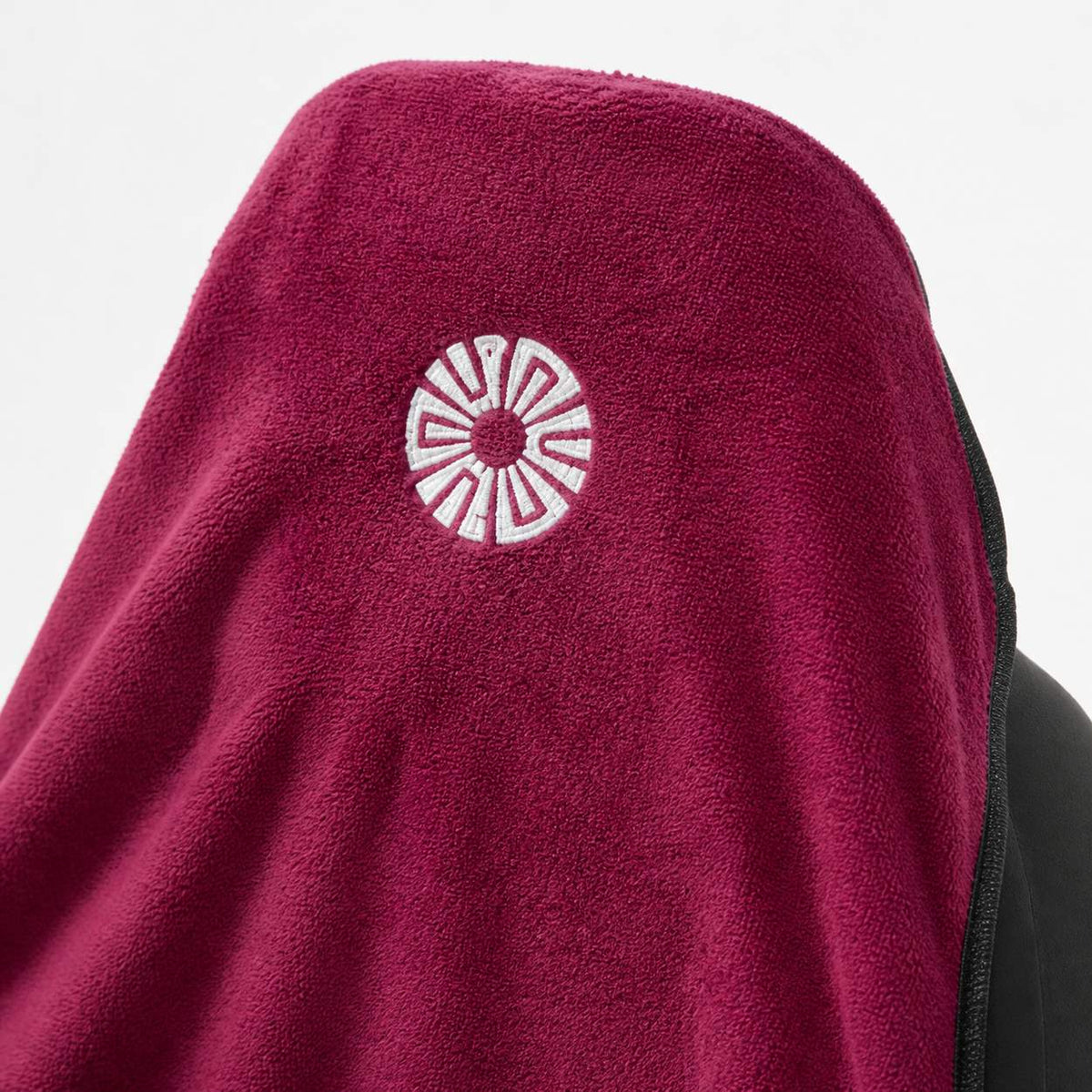 Close-up of the embroidered Solara sun logo on the hood of the Rosa pink car seat towel