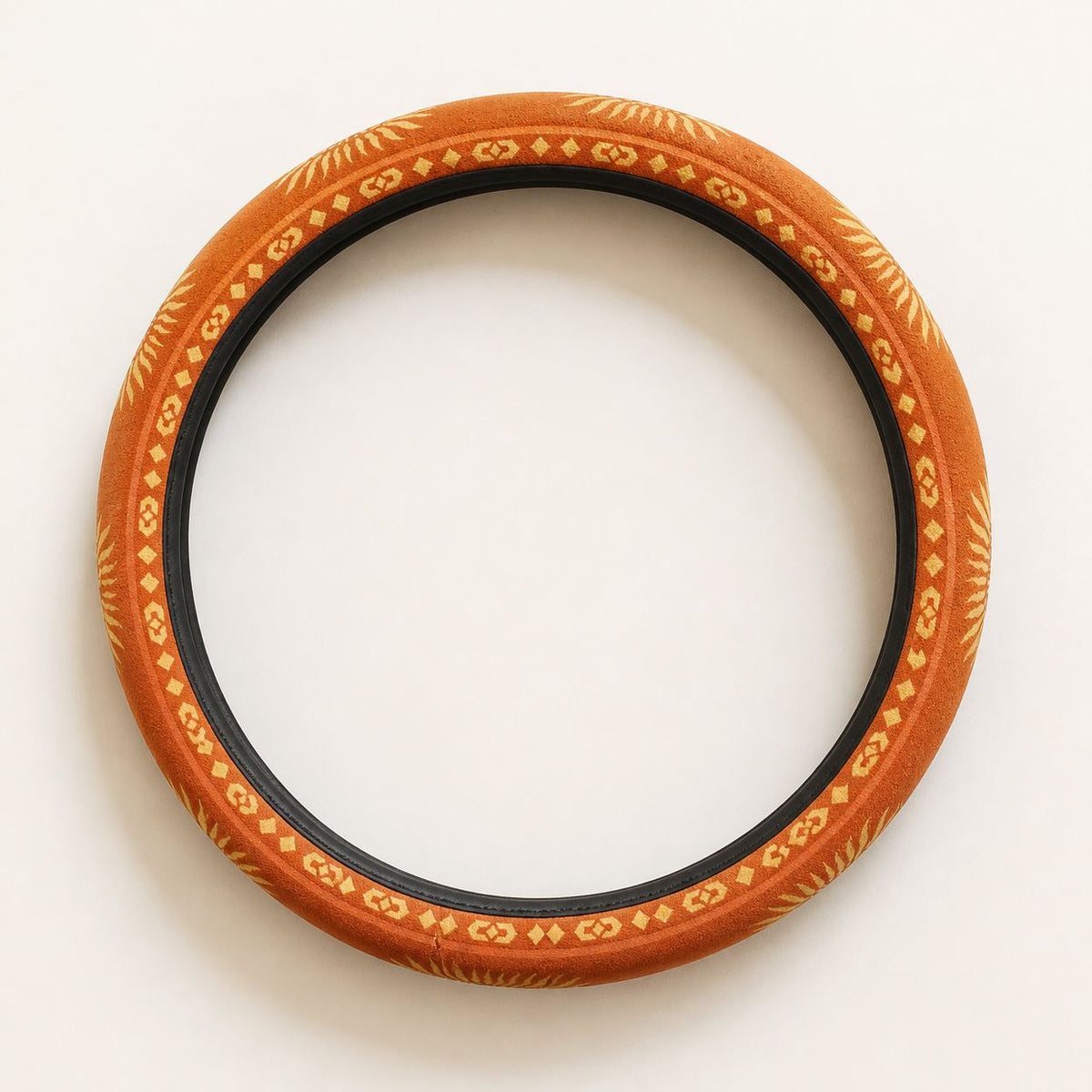 Sol steering wheel cover by Solara laid flat: warm orange sunburst print with a black inner band