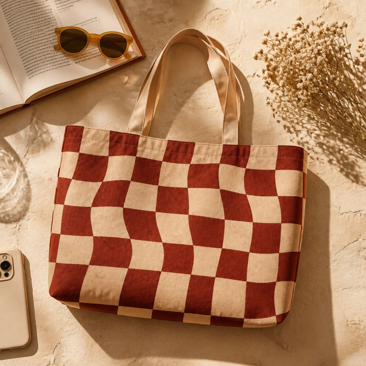 Terra tote bag flat lay with an open book and sunglasses