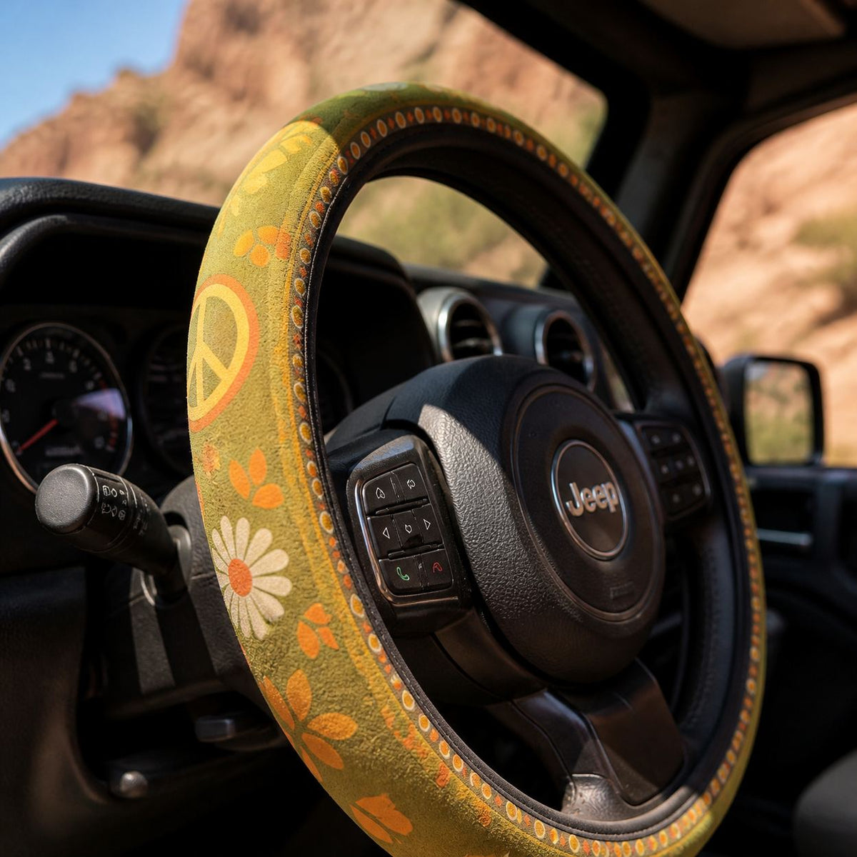 Close-up of the Woodstock steering wheel cover by Solara on the rim by the spoke, olive green daisy print