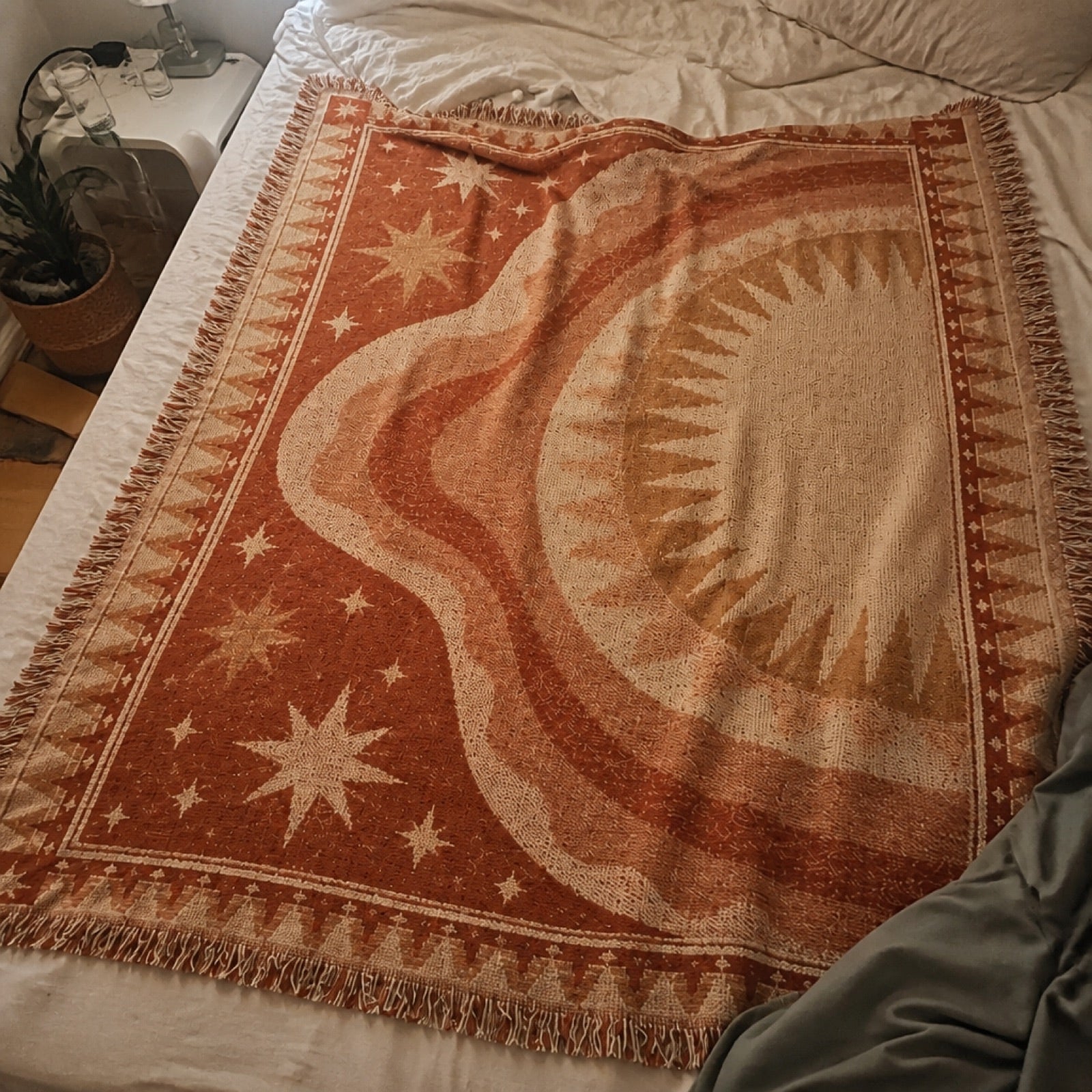 Woven boho blanket laid out on the sand