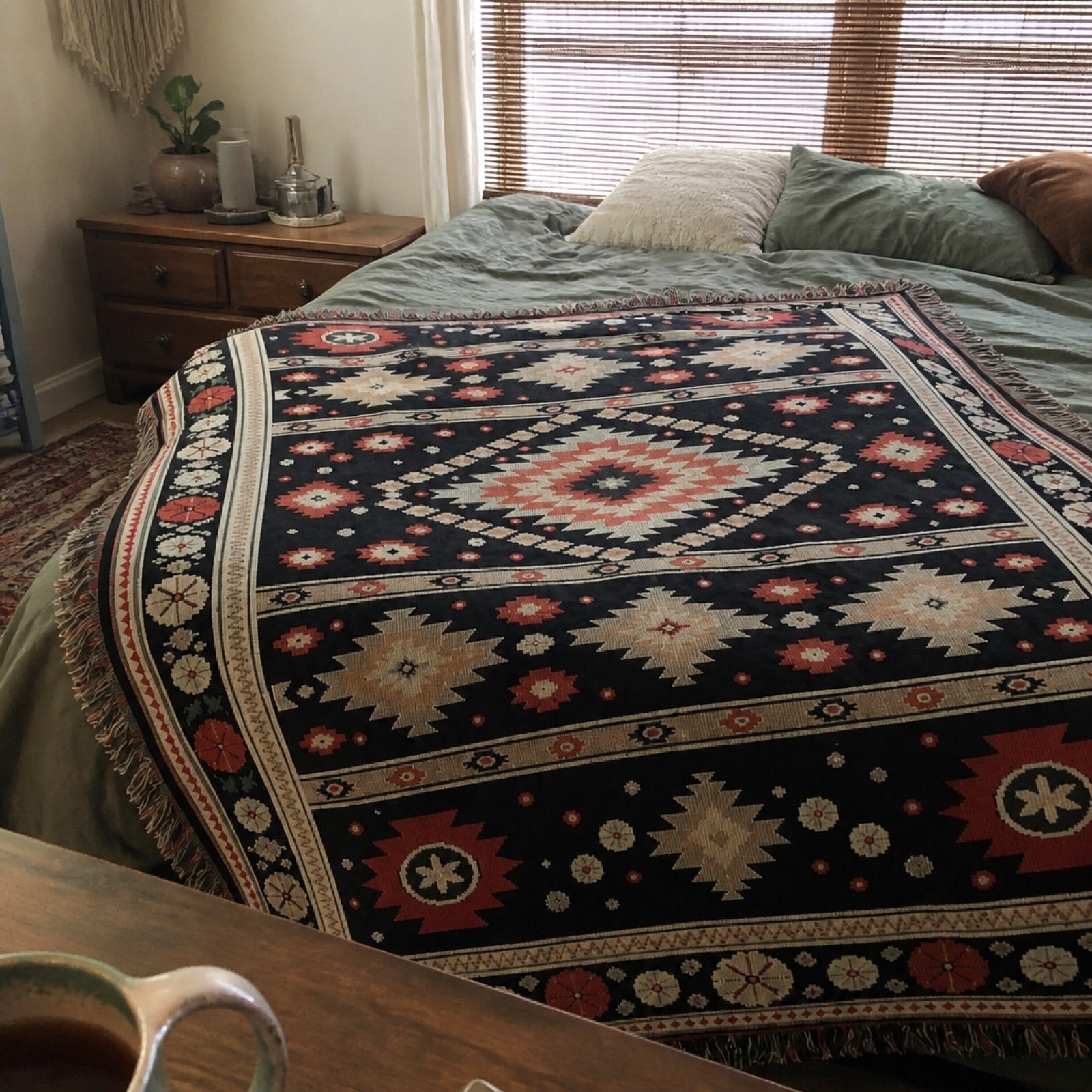 Woven boho blanket spread out at a festival