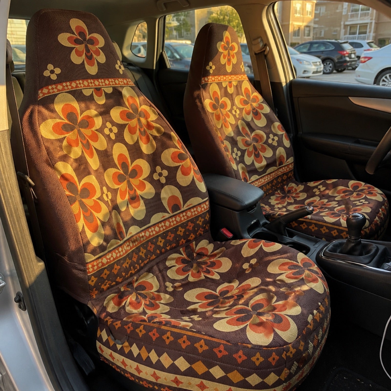 Floral daisy-print seat covers installed on a car's front seats