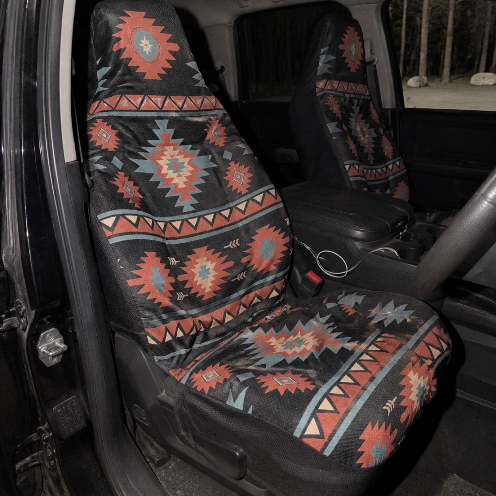 Black and orange Aztec seat covers in a camper van at a campsite | Solara Covers