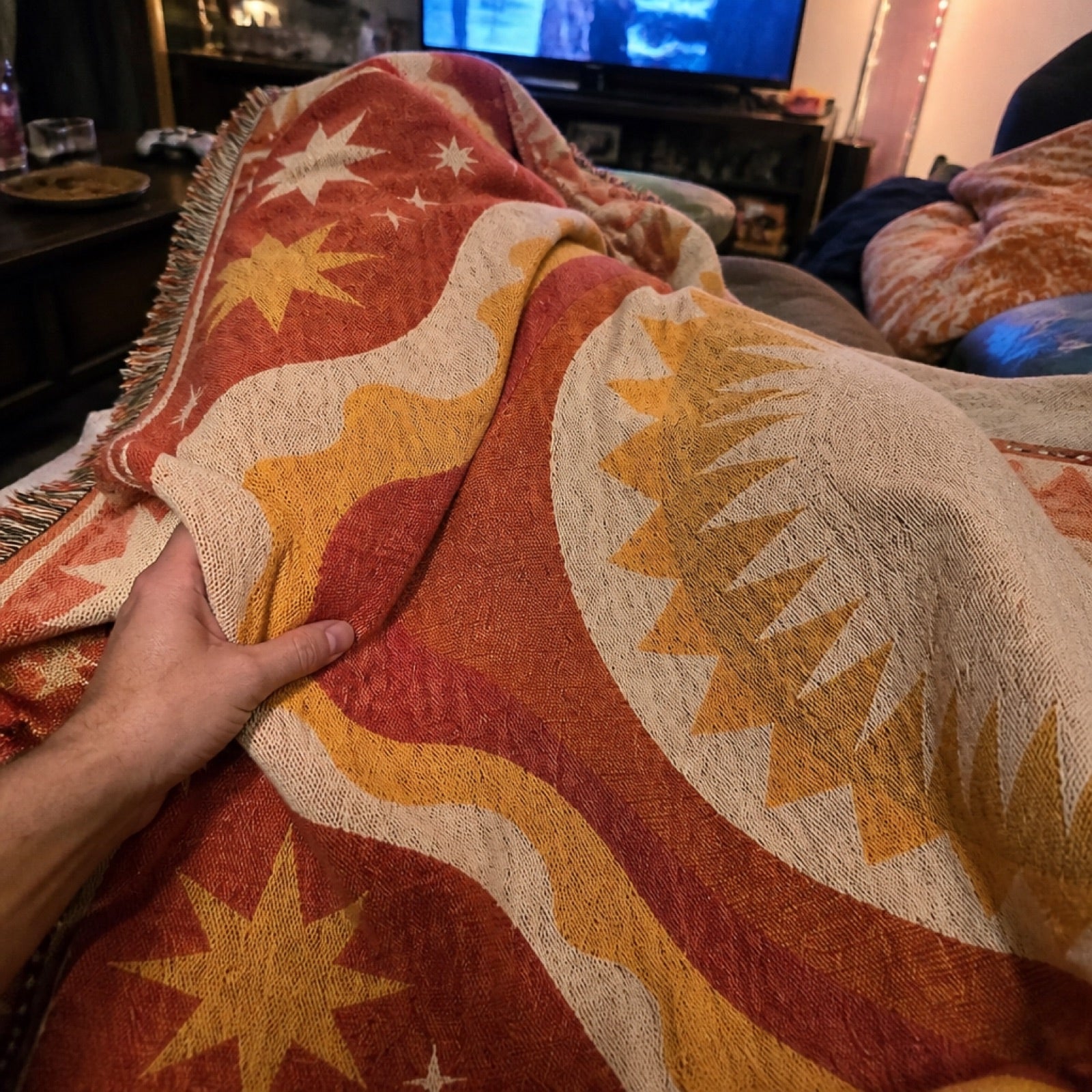 Woven boho blanket wrapped around shoulders at a game