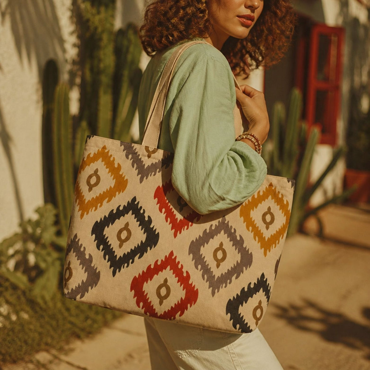 Bali ikat tote bag over the shoulder in front of a cactus wall