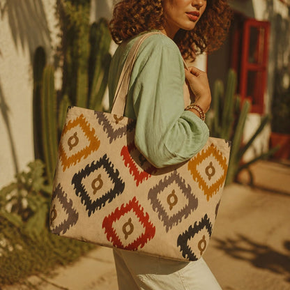 Bali ikat tote bag over the shoulder in front of a cactus wall