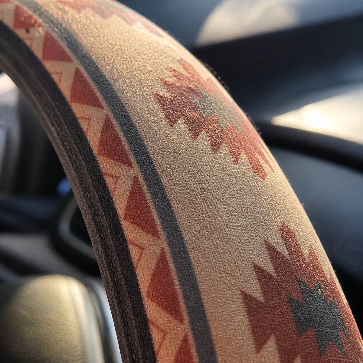Close-up of the soft faux suede on the Indigo steering wheel cover by Solara, cream Aztec print, another angle