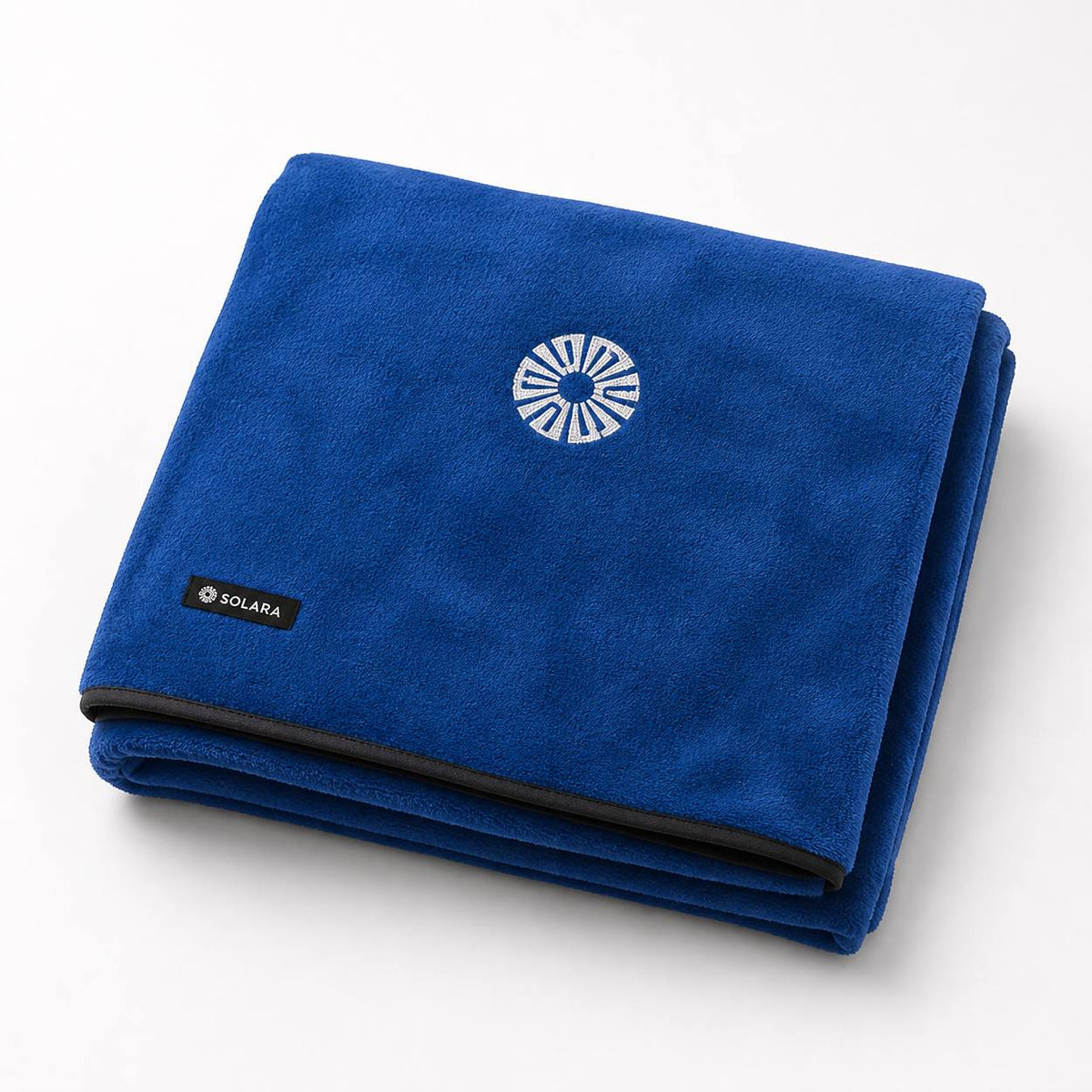 Marina blue car seat towel by Solara folded, embroidered sun logo on top