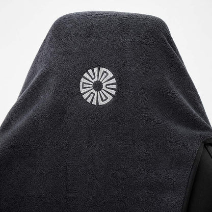 Close-up of the embroidered Solara sun logo on the hood of the Neblina grey car seat towel