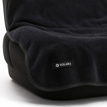 Close-up of the Solara label and bound edge on the Noche black car seat towel