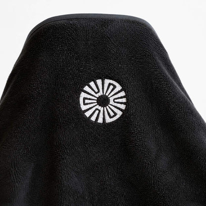Close-up of the embroidered Solara sun logo on the hood of the Noche black car seat towel