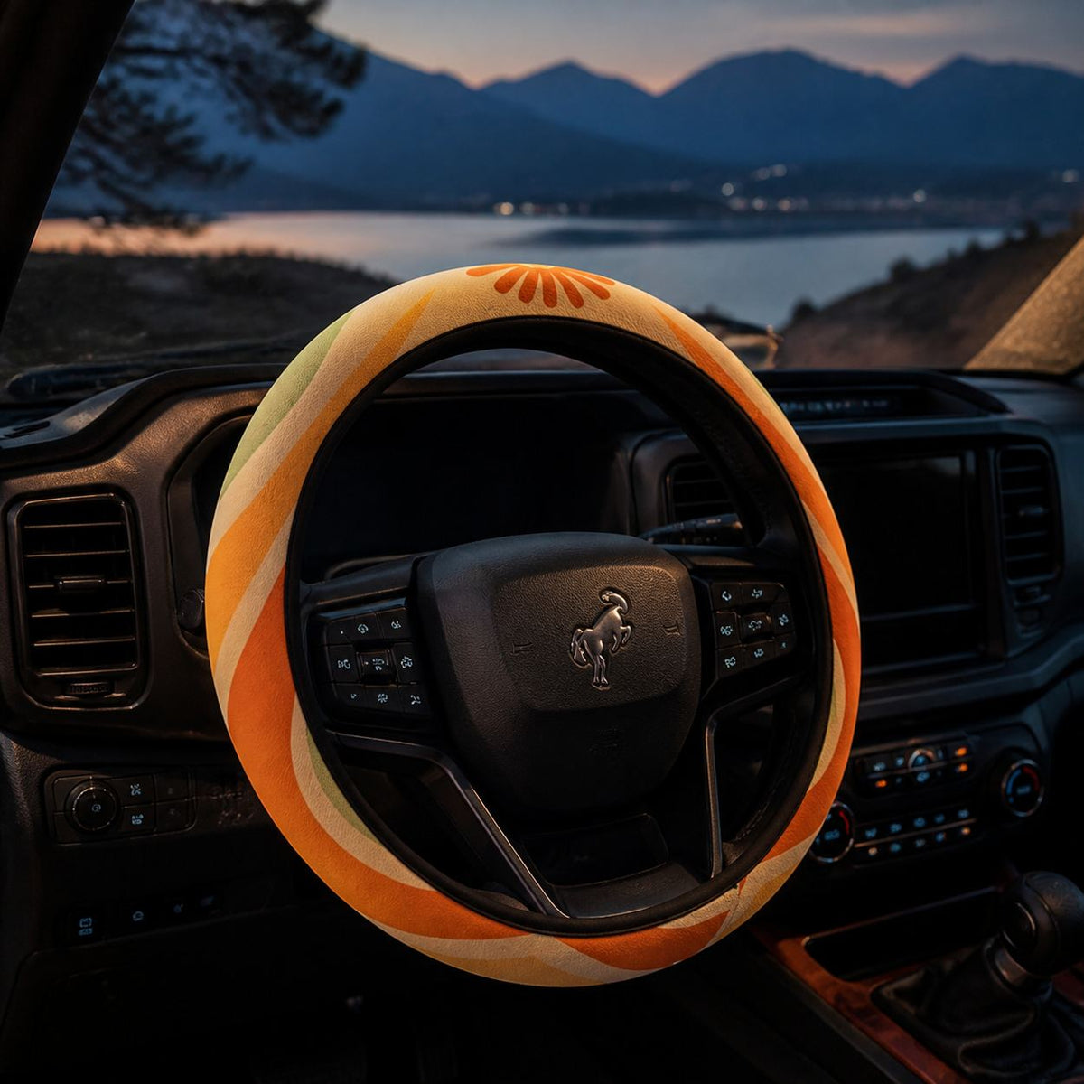 Ripple steering wheel cover by Solara on the wheel at dusk, lake and mountain view