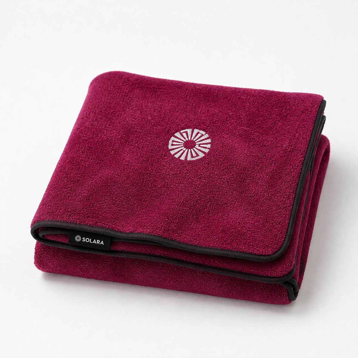 Rosa pink car seat towel by Solara folded, embroidered sun logo on top