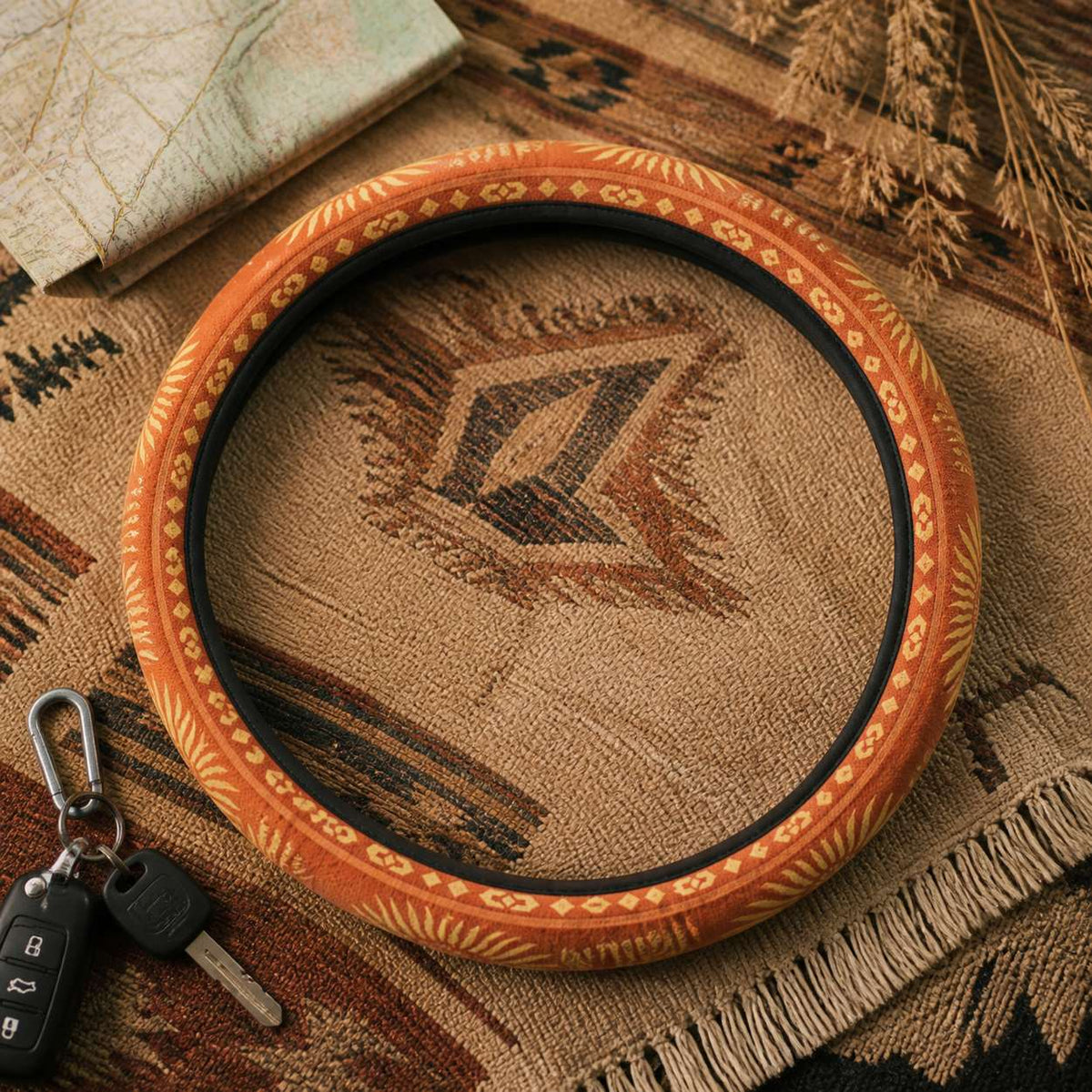 Sol steering wheel cover by Solara on a woven blanket next to car keys, warm orange sunburst print