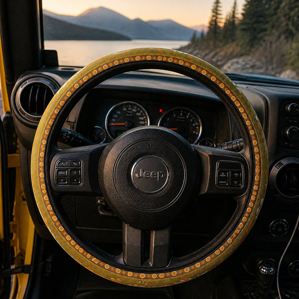 Woodstock steering wheel cover by Solara on the wheel at dusk, lake and mountain view