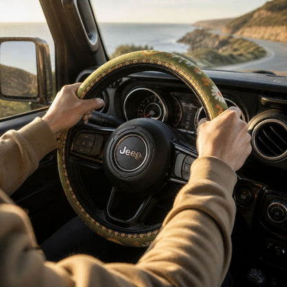 Hands on the Woodstock steering wheel cover by Solara while driving, olive green daisy print