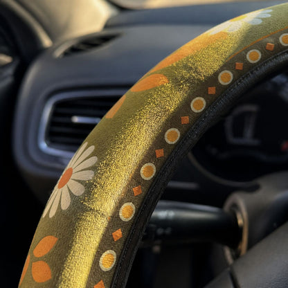 Close-up of the soft faux suede on the Woodstock steering wheel cover by Solara, olive green daisy print