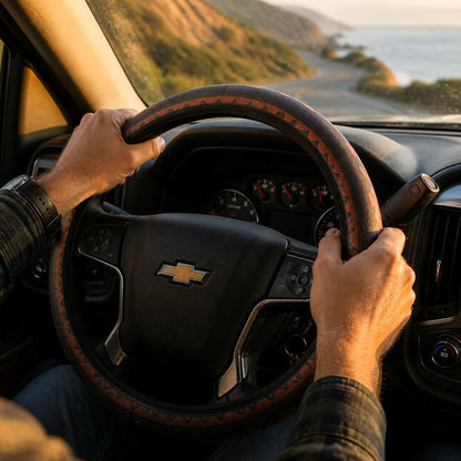 Hands on the Zara steering wheel cover by Solara while driving, black and orange Aztec print